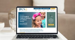 JFCS of Southern Arizona Website Homepage displayed on macbook air placed on table in living room